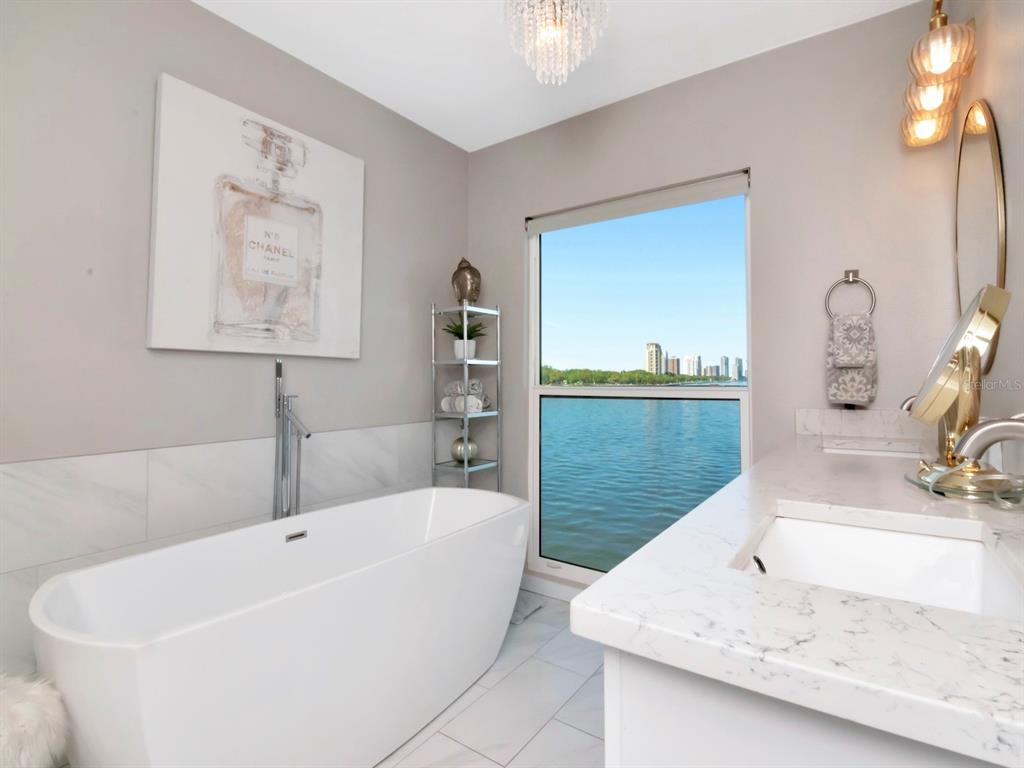 2807 West Hawthorne Road, Unit 11 Tampa, FL 33611 - Photo 36 of 76 a bathroom with a tub a sink and mirror