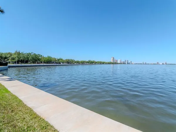 a view of a lake with couches and wooden floor