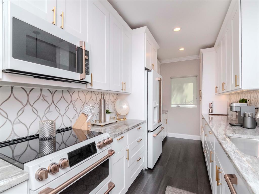 2807 West Hawthorne Road, Unit 11 Tampa, FL 33611 - Photo 9 of 76 a kitchen with stainless steel appliances a stove a microwave and cabinets
