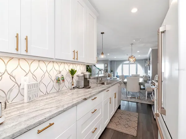 a living room with furniture a flat screen tv and large windows