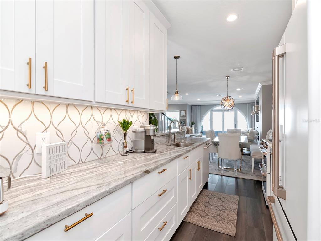 2807 West Hawthorne Road, Unit 11 Tampa, FL 33611 - Photo 10 of 76 a large white kitchen with granite countertop a sink white cabinets and a granite counter tops