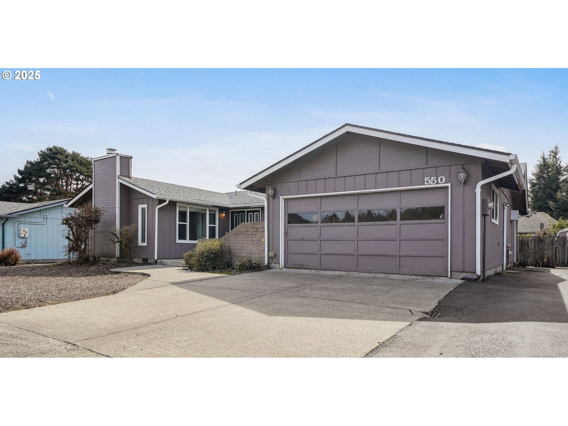 550 Evergreen Loop Reedsport, OR 97467 - Photo 2 of 35 a front view of a house with a yard and garage