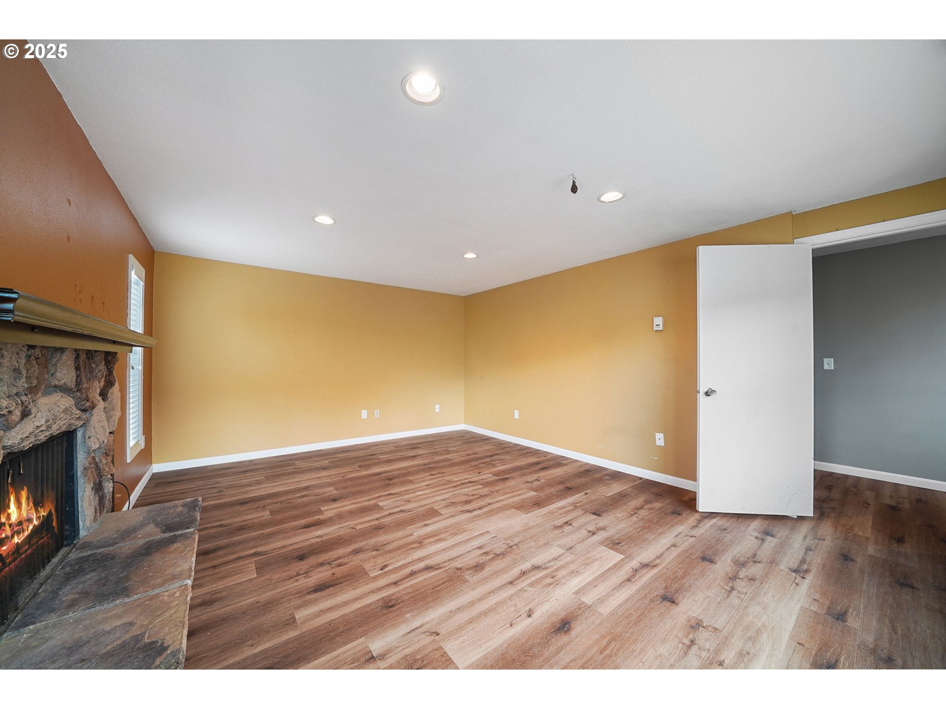 550 Evergreen Loop Reedsport, OR 97467 - Photo 21 of 35 a view of an empty room with wooden floor and a fireplace