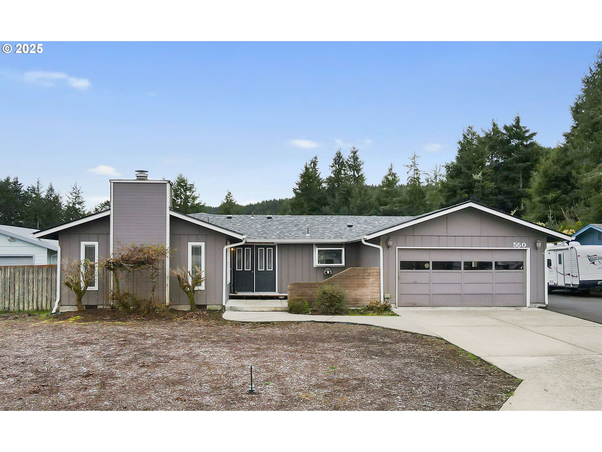 550 Evergreen Loop Reedsport, OR 97467 - Photo 4 of 35 a view of a yard in front of a house with large trees