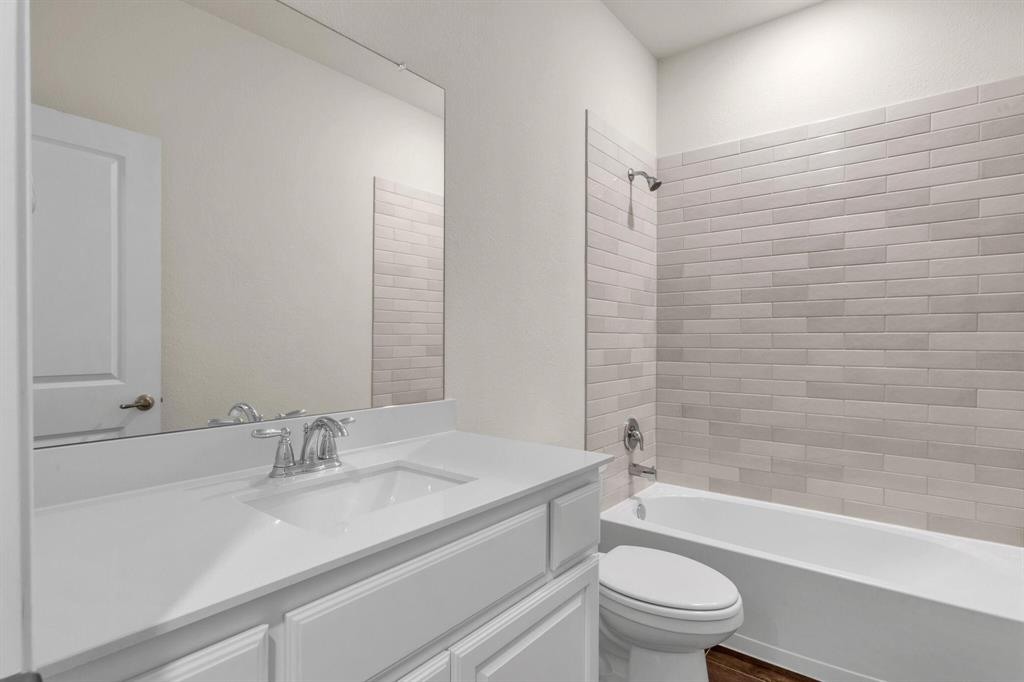 3106 Maverick Drive Forney, TX 75126 - Photo 16 of 32 a bathroom with a granite countertop sink a toilet and shower