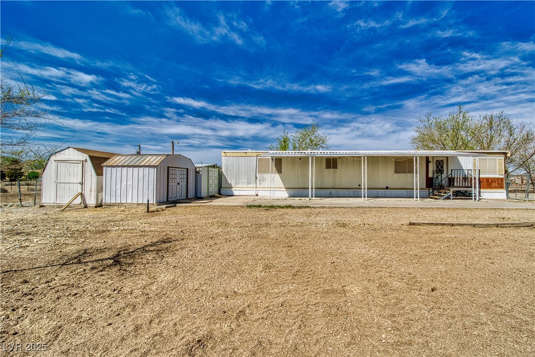 2631 Retread Road Pahrump, NV 89048 - Photo 3 of 18 Back of house featuring a storage shed, a patio, and an outdoor structure