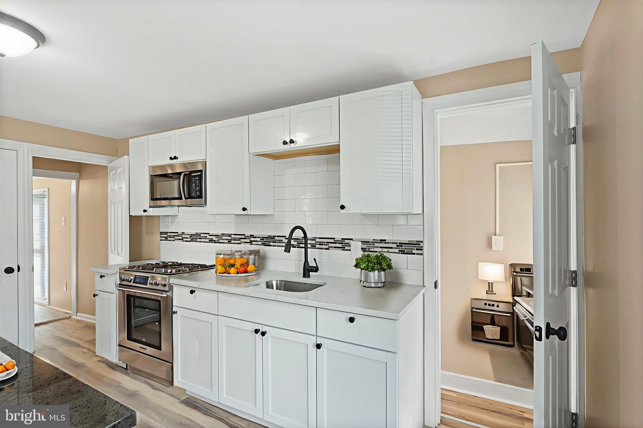 50 Pine Street Beverly, NJ 08010 - Photo 5 of 18 a kitchen with stainless steel appliances a stove a sink and white cabinets