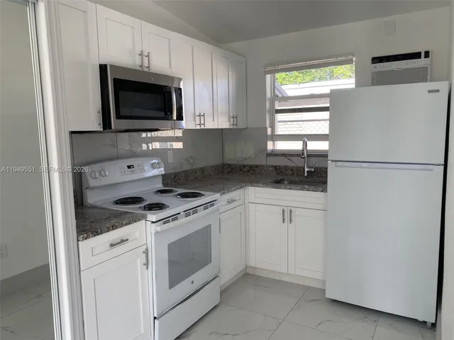 a kitchen with white cabinets and white appliances