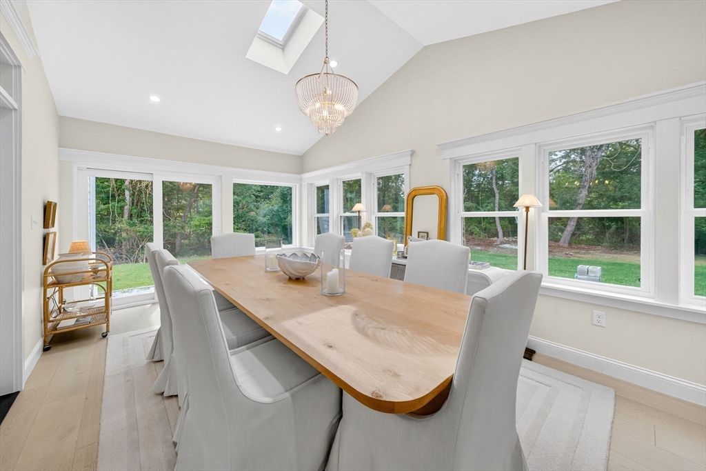 738 Smith Neck Road Dartmouth, MA 02748 - Photo 15 of 42 a dining room with furniture a chandelier and wooden floor