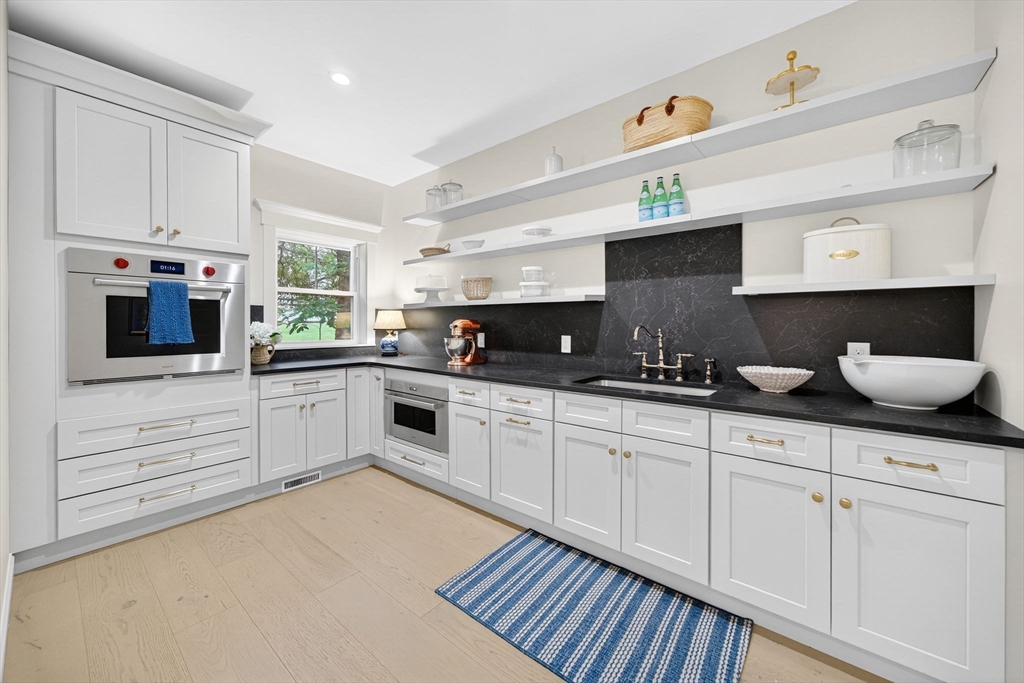 738 Smith Neck Road Dartmouth, MA 02748 - Photo 16 of 42 a kitchen with granite countertop white cabinets and white appliances