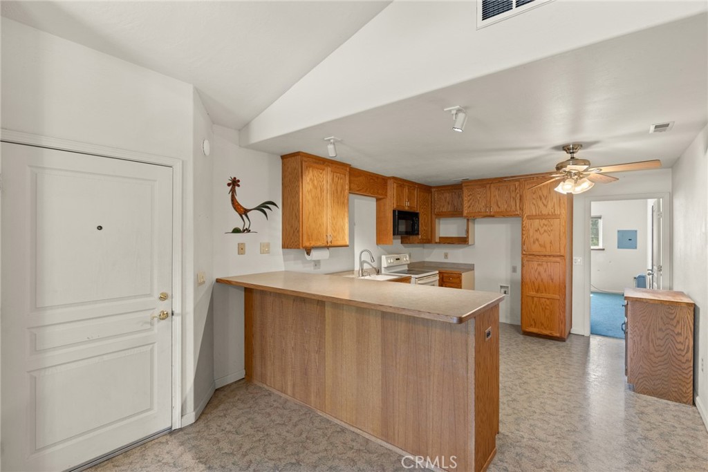 3582 Keefer Road Chico, CA 95973 - Photo 51 of 75 a kitchen with kitchen island a sink a stove a refrigerator cabinets and living room view
