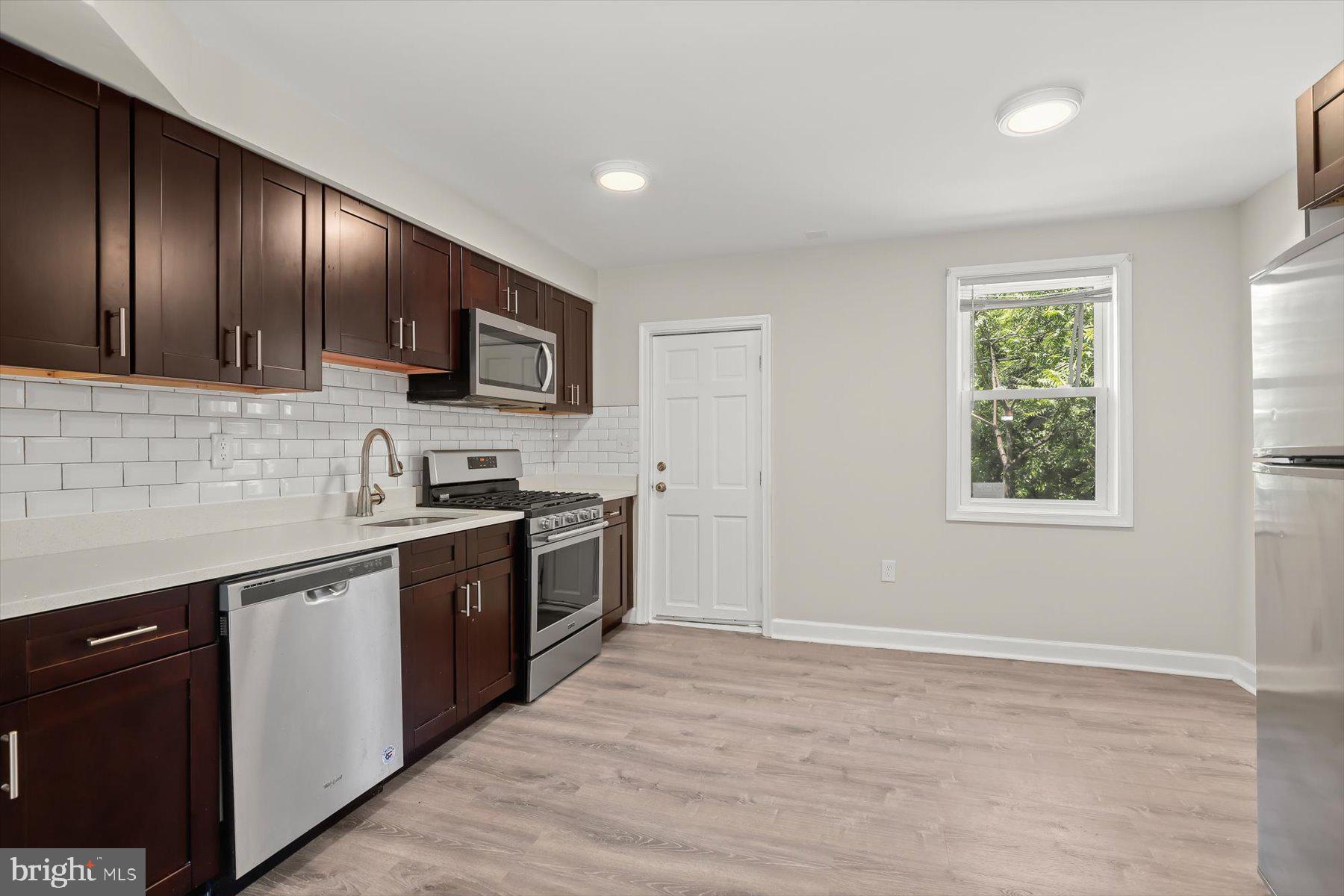 1044 Ellicott Driveway Baltimore, MD 21216 - Photo 5 of 26 a kitchen with stainless steel appliances granite countertop wooden cabinets a stove top oven a sink and dishwasher