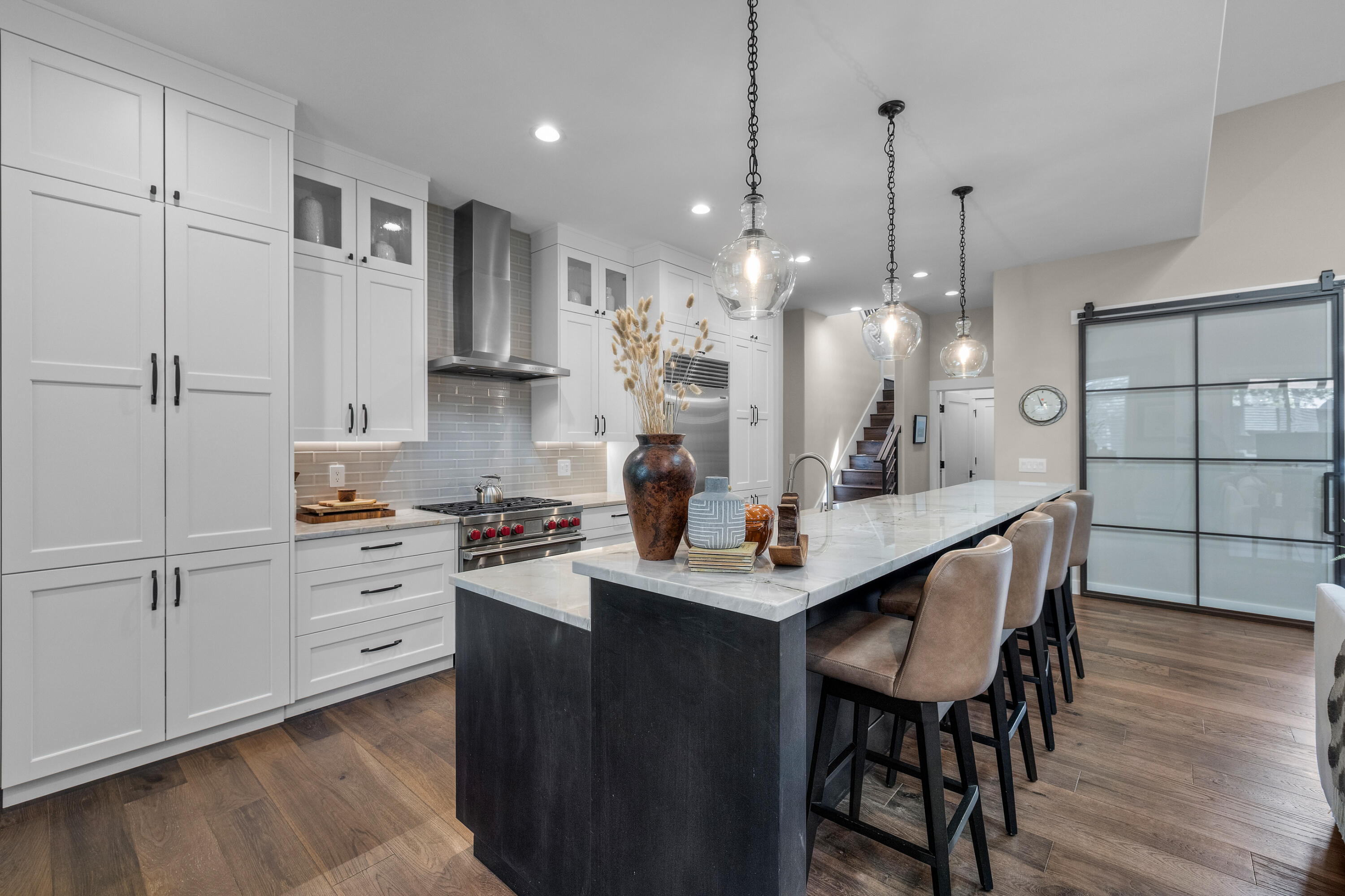 19460 Chip Shot Lane Bend, OR 97702 - Photo 10 of 56 a kitchen with stainless steel appliances kitchen island granite countertop a table chairs and a wooden floor