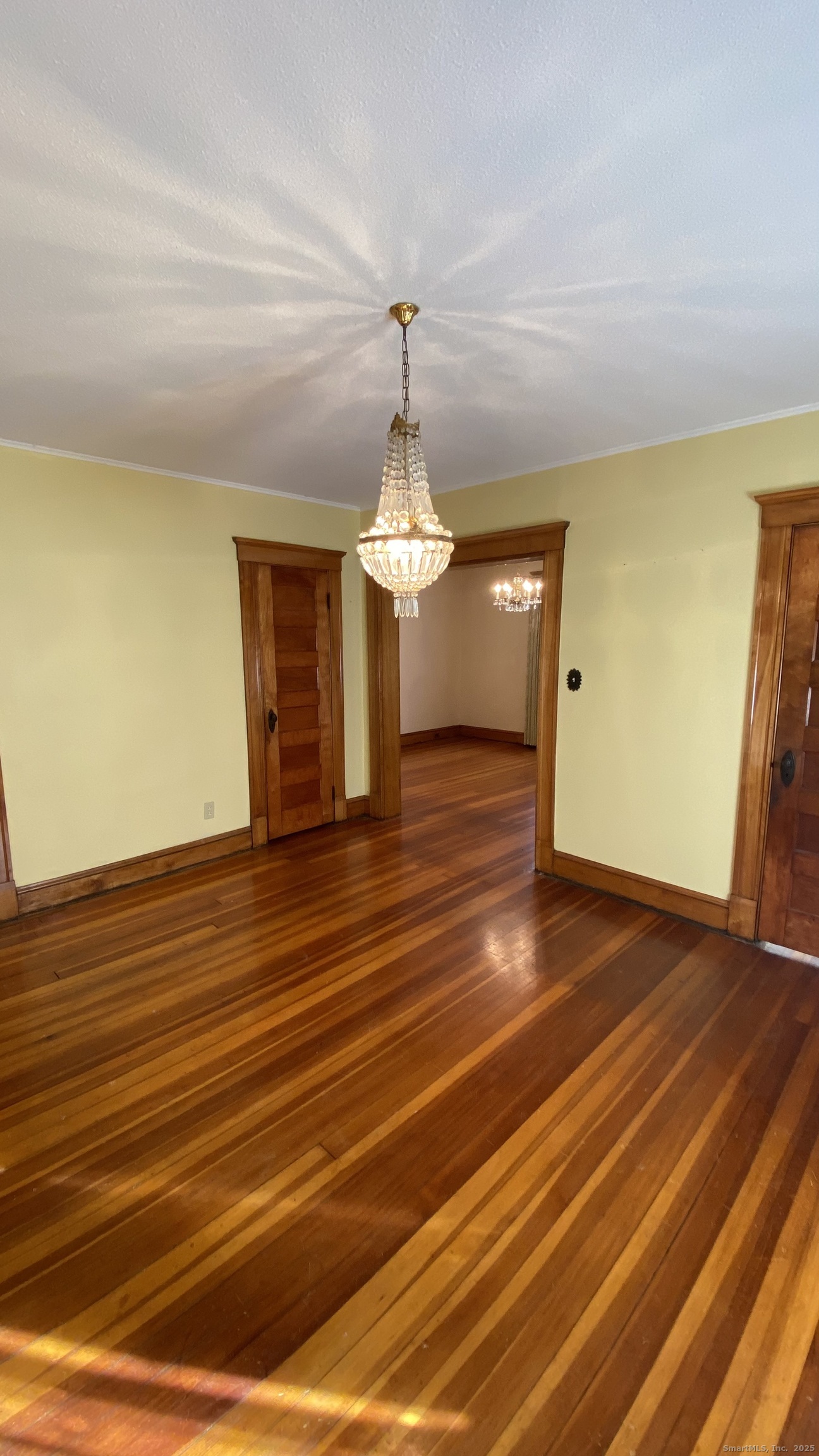 135 Elm Street, Unit 1 Winsted, CT 06098 - Photo 19 of 32 a view of an empty room with wooden floor and chandelier