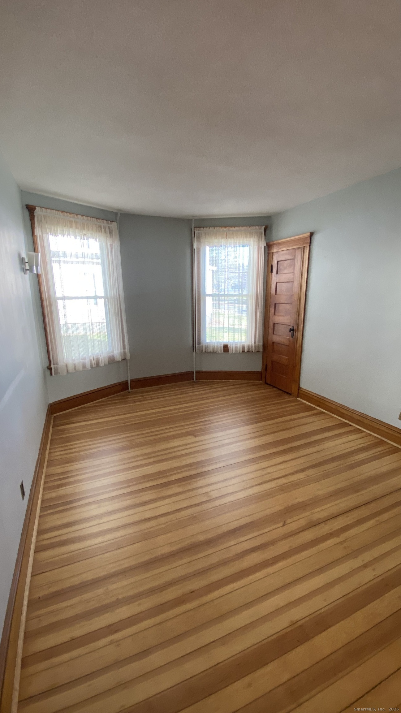 135 Elm Street, Unit 1 Winsted, CT 06098 - Photo 20 of 32 an empty room with wooden floor and windows