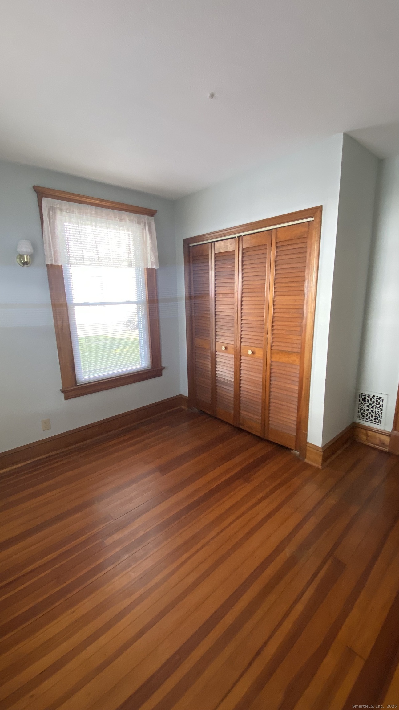 135 Elm Street, Unit 1 Winsted, CT 06098 - Photo 21 of 32 a view of an empty room with wooden floor and a window