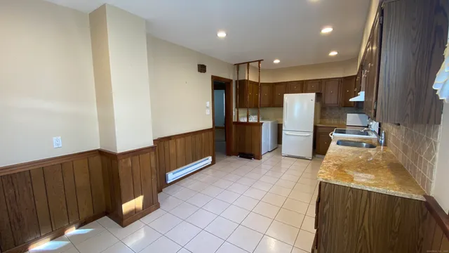 a kitchen with stainless steel appliances kitchen island granite countertop a refrigerator and a sink