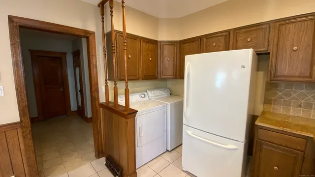 a white refrigerator freezer and a stove sitting inside of a kitchen