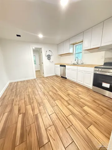 a large white kitchen with granite countertop a sink