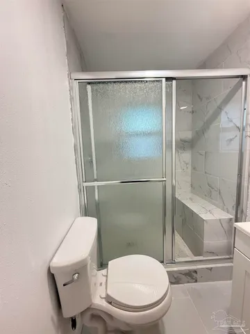 a bathroom with a toilet and a shower