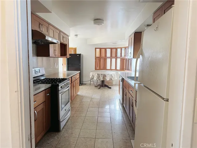 a kitchen with stainless steel appliances granite countertop a refrigerator and a stove