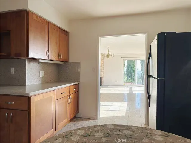 a kitchen with stainless steel appliances granite countertop a refrigerator and a stove top oven