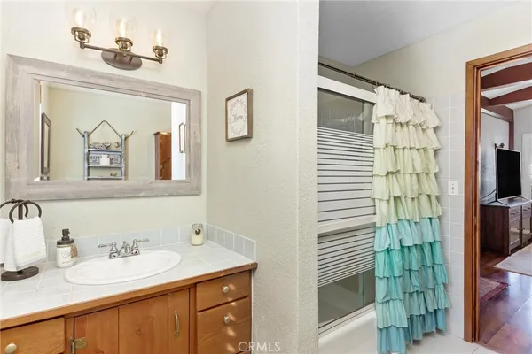 a bathroom with a sink a mirror and a shower