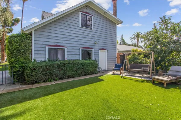 a view of a house with a yard and sitting area