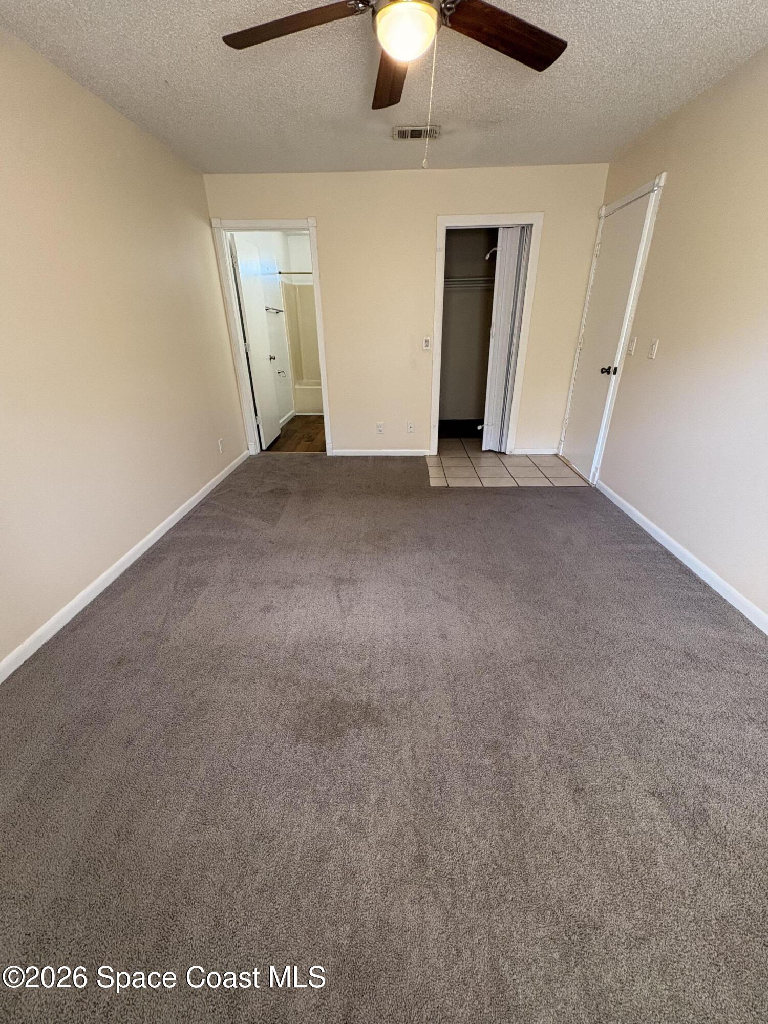 2000 Agora Circle Southeast, Unit 201 Palm Bay, FL 32909 - Photo 4 of 10 an empty room with a ceiling fan and carpet