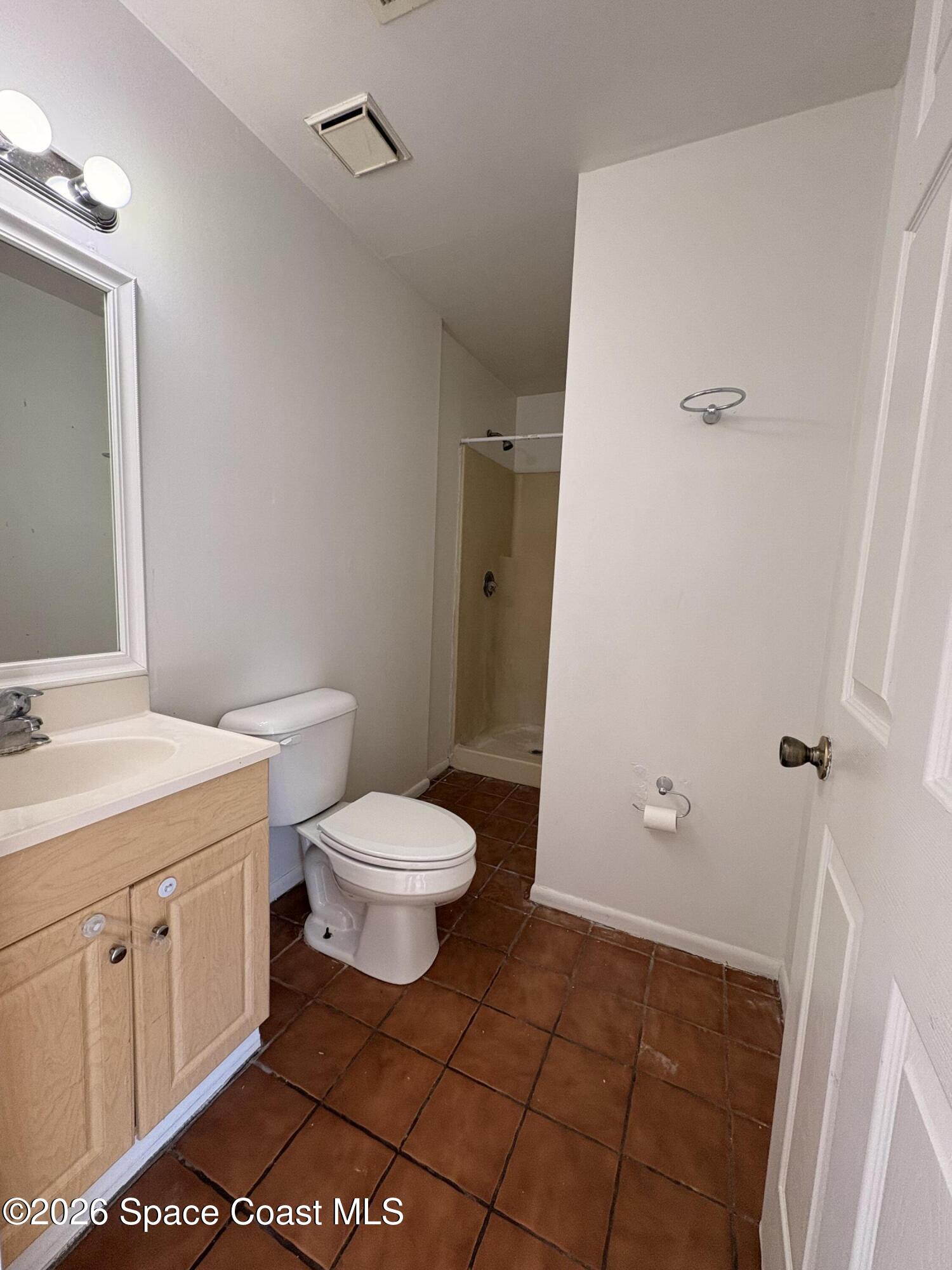 2000 Agora Circle Southeast, Unit 201 Palm Bay, FL 32909 - Photo 7 of 10 a bathroom with a toilet a sink and shower