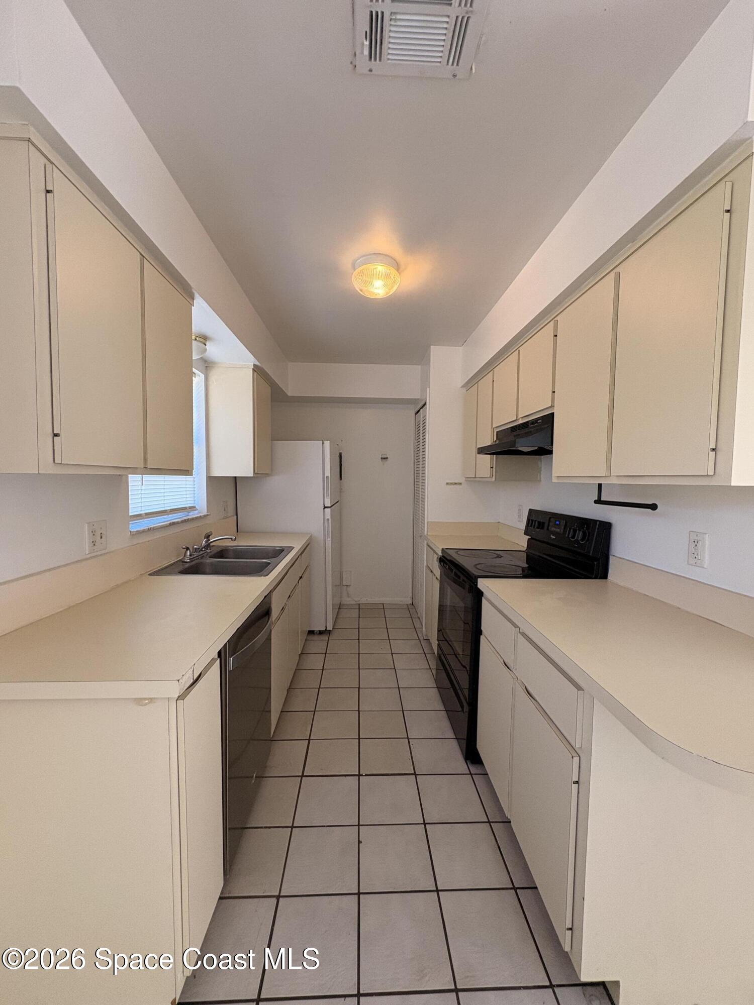2000 Agora Circle Southeast, Unit 201 Palm Bay, FL 32909 - Photo 9 of 10 a kitchen with a sink a stove cabinets and a window