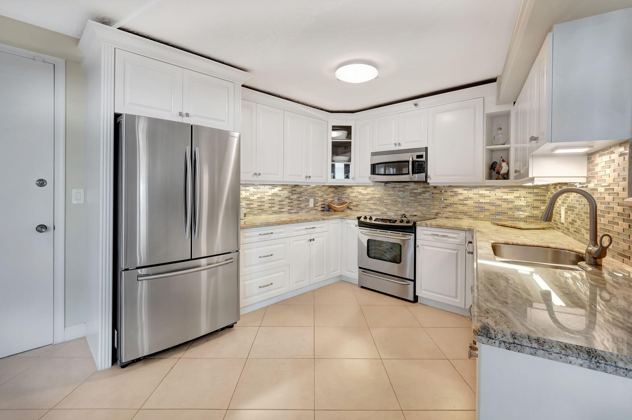 4545 North Ocean Boulevard, Unit 11C Boca Raton, FL 33431 - Photo 18 of 58 a kitchen with stainless steel appliances granite countertop a refrigerator sink and stove