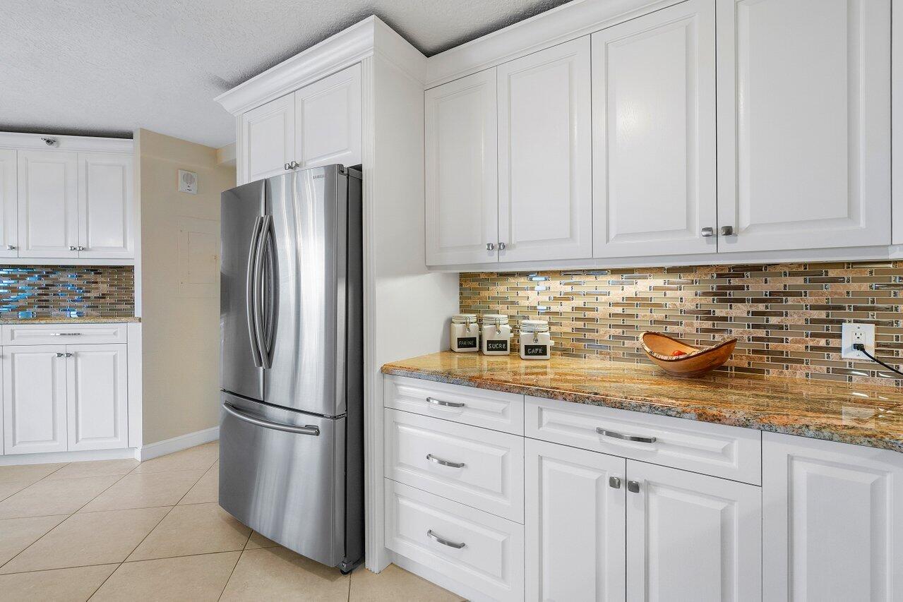 4545 North Ocean Boulevard, Unit 11C Boca Raton, FL 33431 - Photo 21 of 58 a kitchen with granite countertop white cabinets and stainless steel appliances
