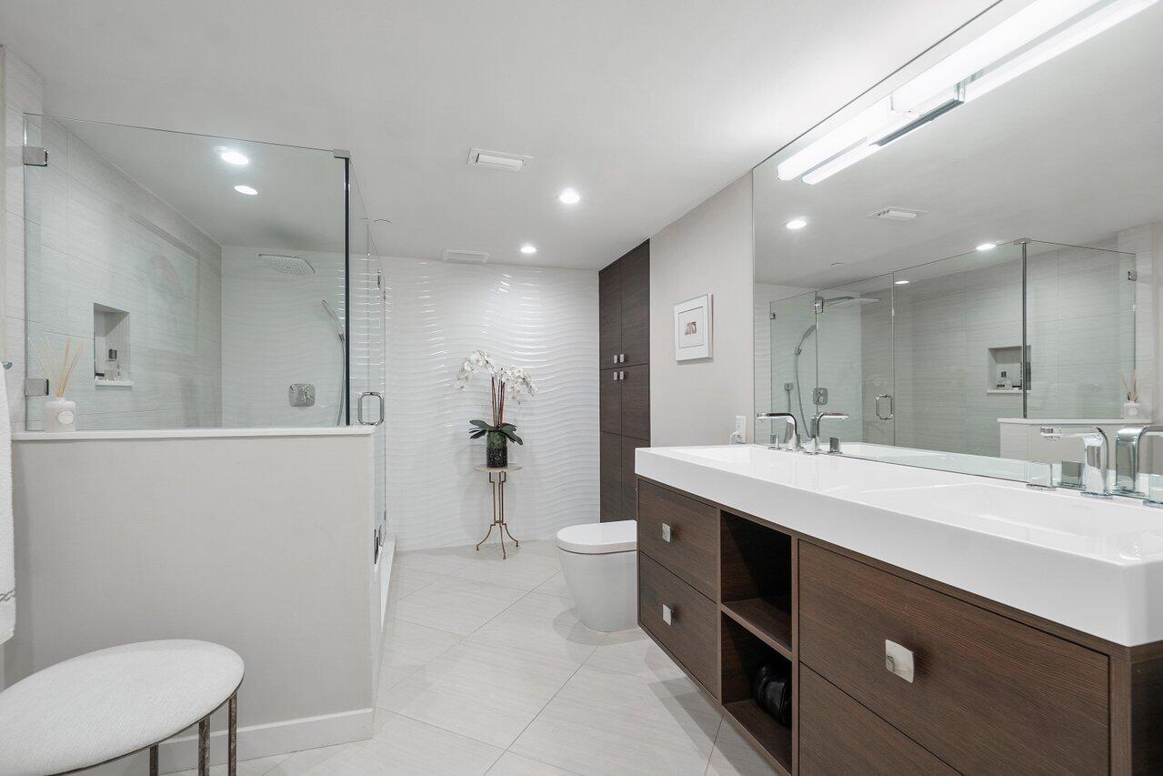 4545 North Ocean Boulevard, Unit 11C Boca Raton, FL 33431 - Photo 33 of 58 a bathroom with a double vanity sink toilet and a mirror