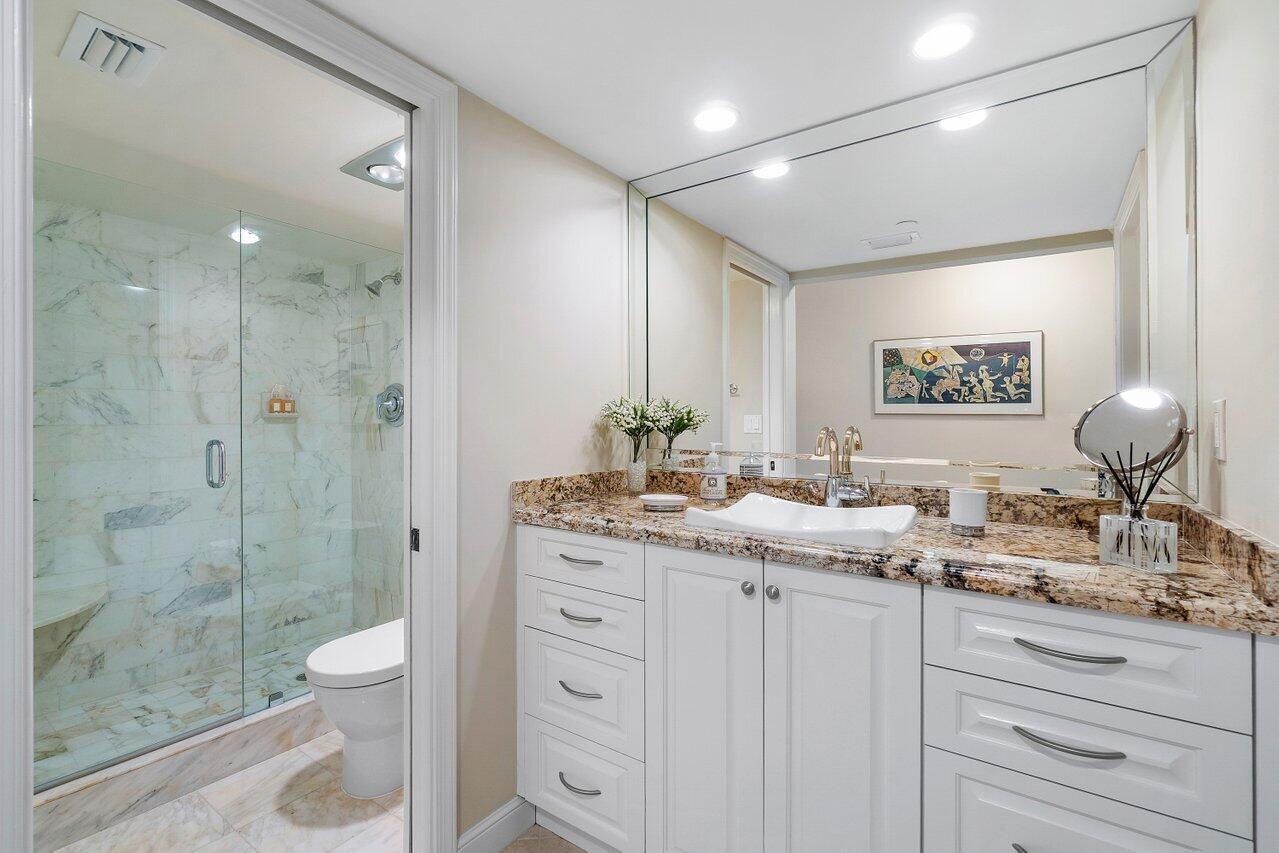 4545 North Ocean Boulevard, Unit 11C Boca Raton, FL 33431 - Photo 41 of 58 a bathroom with a granite countertop sink a toilet a mirror and shower