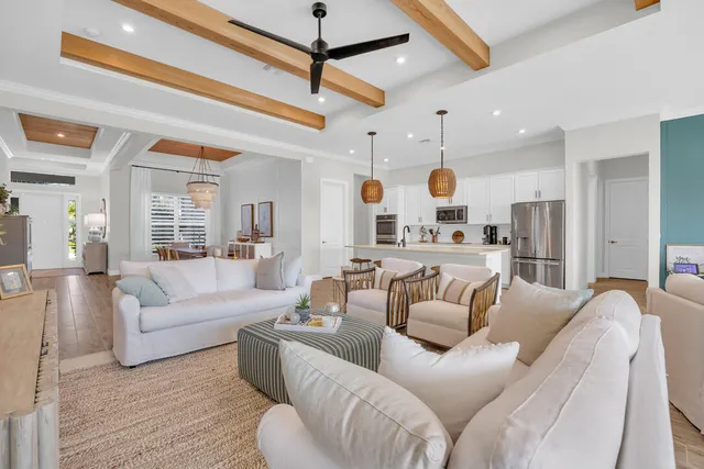 a living room with furniture kitchen view and a chandelier