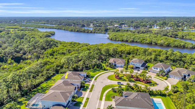 an aerial view of a house with a garden and lake view
