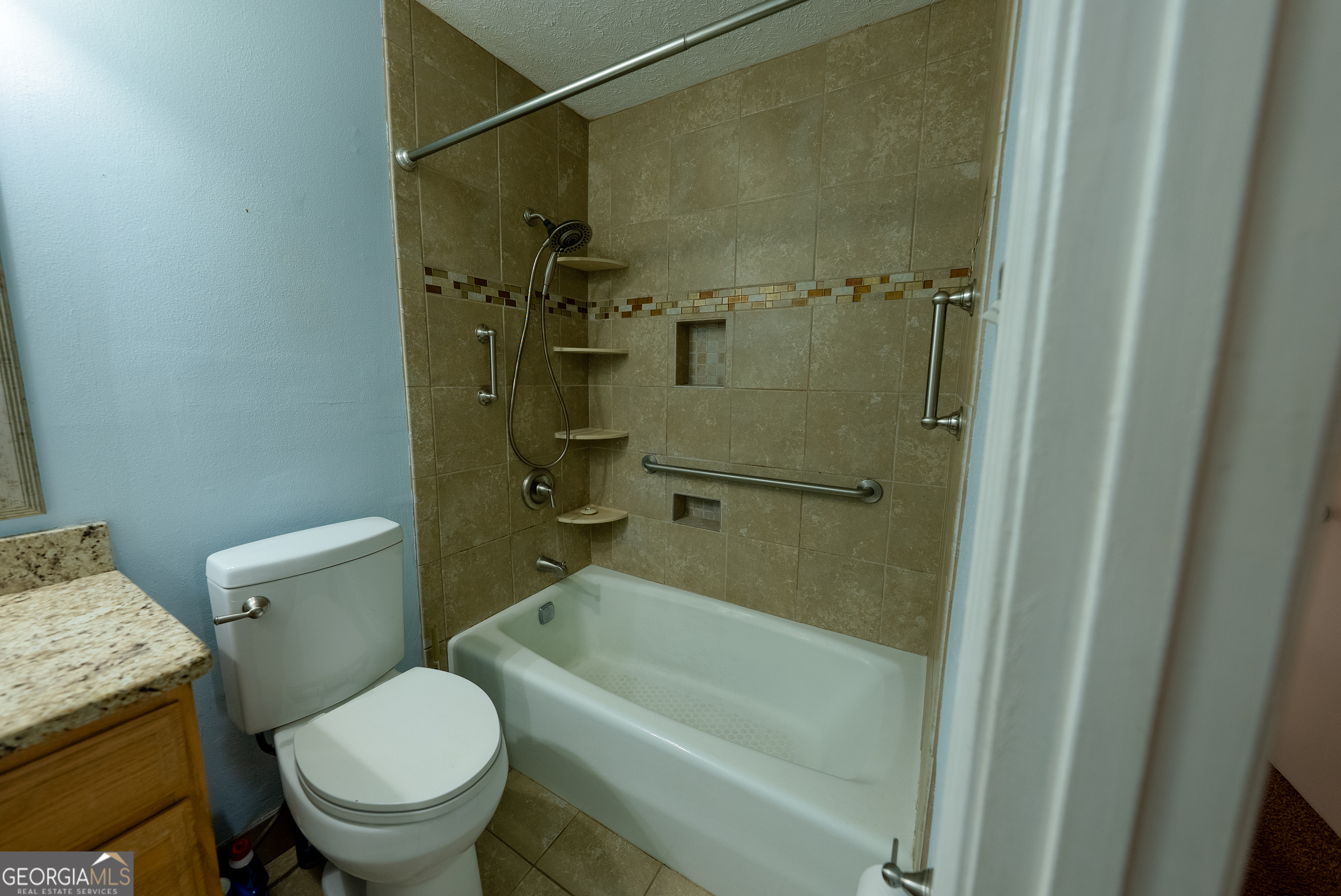 953 McCullough Road Stockbridge, GA 30281 - Photo 26 of 29 a bathroom with a granite countertop toilet a sink and shower