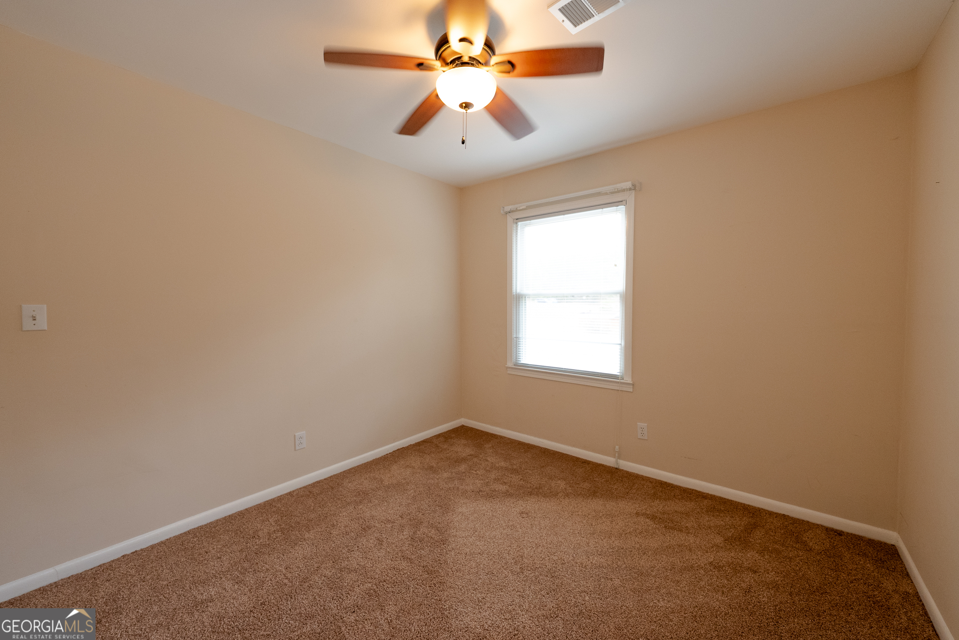 953 McCullough Road Stockbridge, GA 30281 - Photo 8 of 29 an empty room with a window and a fan