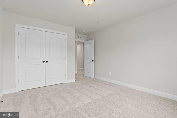 a view of an empty room with closet area