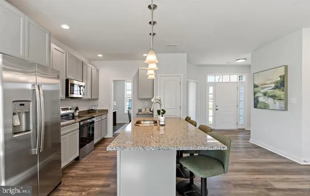 a kitchen with stainless steel appliances granite countertop a sink refrigerator and cabinets