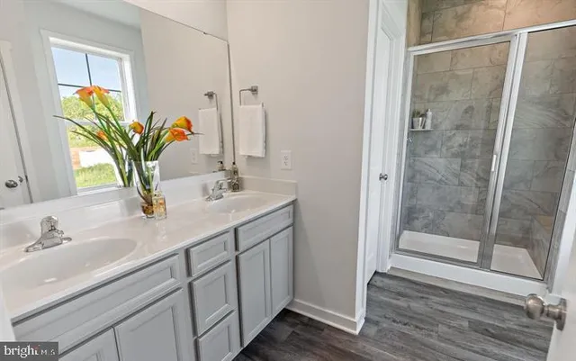 a bathroom with a granite countertop sink a mirror and a shower