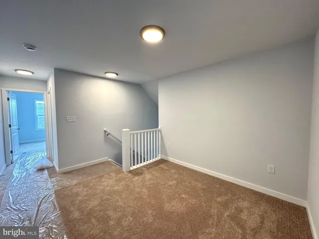 an empty room with a ceiling fan and window