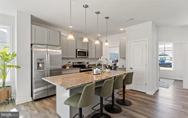 a kitchen with a table chairs refrigerator and microwave