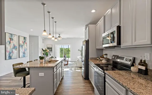 a kitchen with stainless steel appliances granite countertop a stove a sink and a refrigerator
