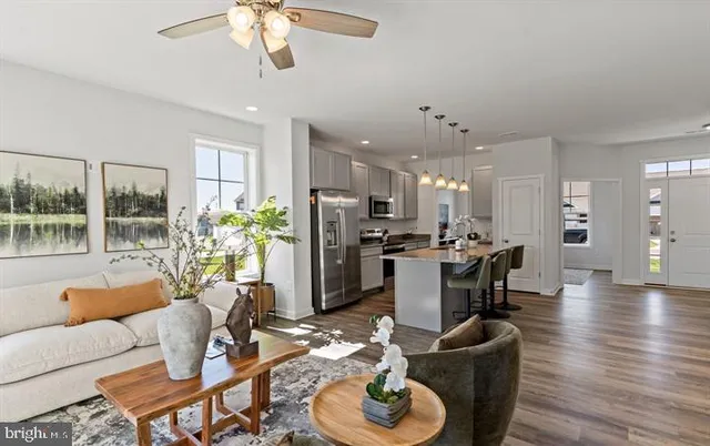 a living room with furniture kitchen and a chandelier