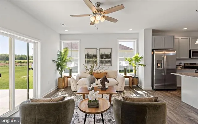 a living room with furniture a large window and a chandelier