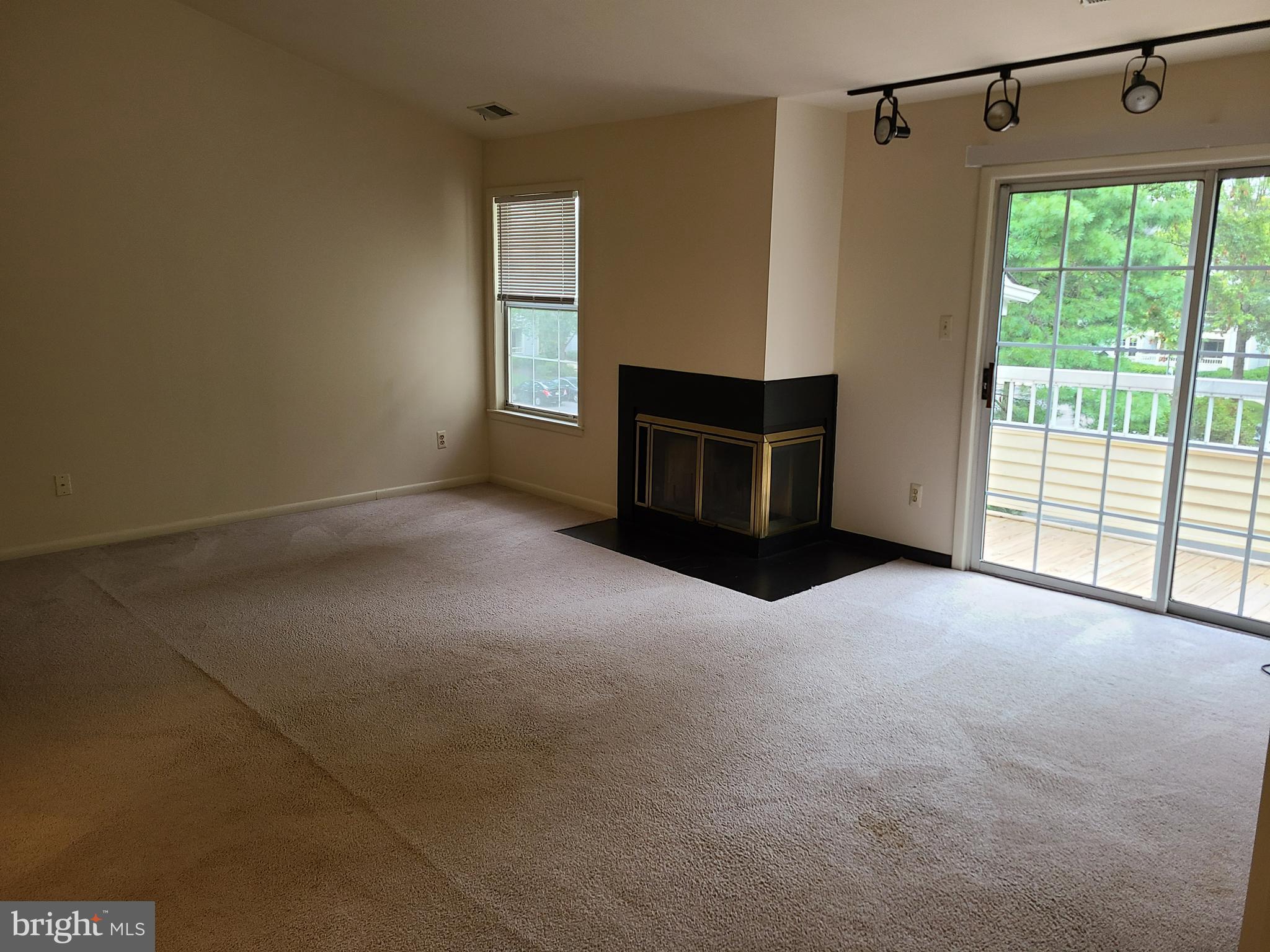 308 Trinity Court, Unit 11 Princeton, NJ 08540 - Photo 2 of 7 a view of an empty room with a fireplace and a window