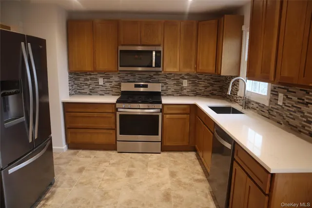 a kitchen with stainless steel appliances granite countertop a stove microwave and refrigerator