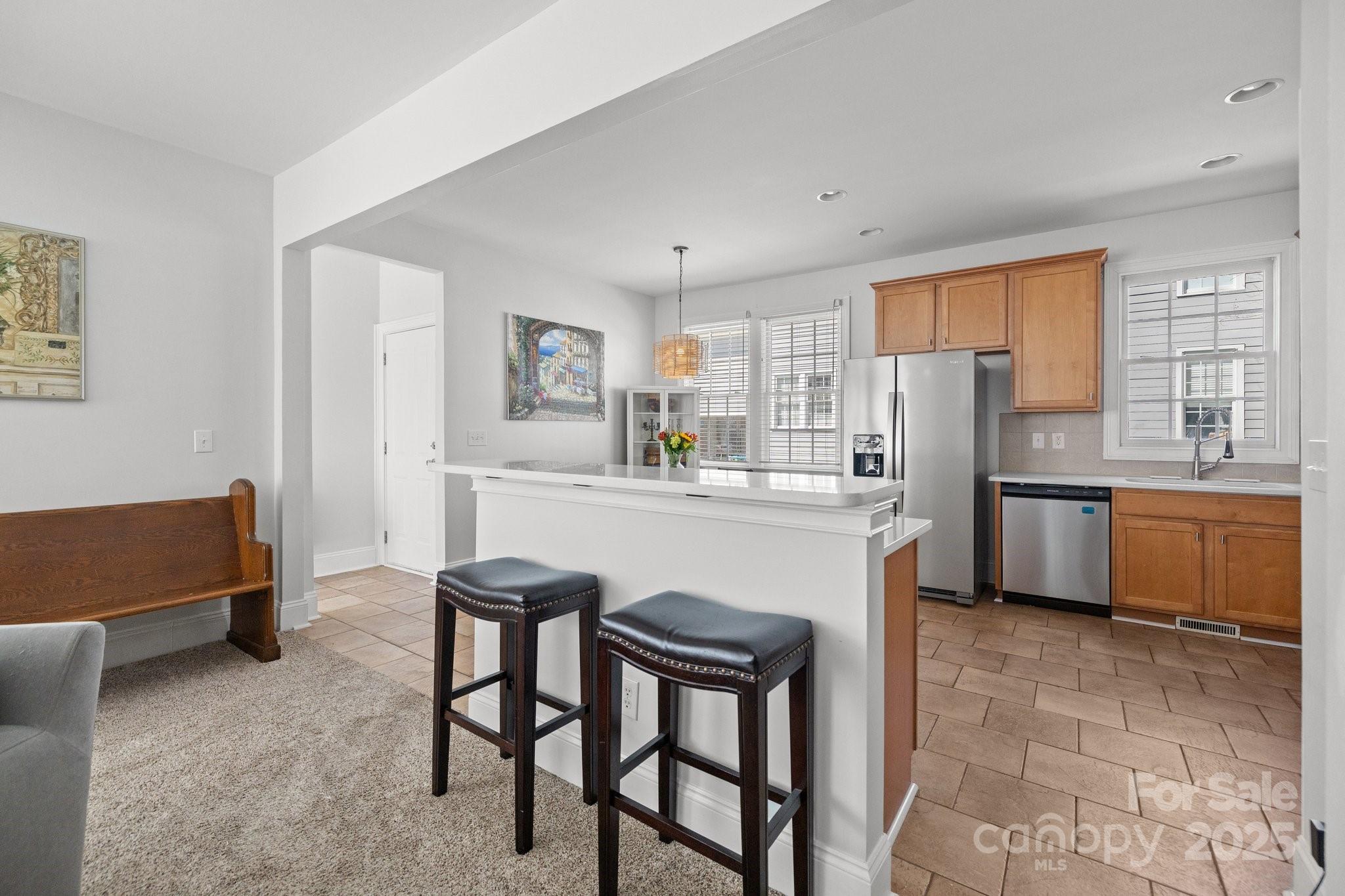3208 Fifth Baxter Crossing Fort Mill, SC 29708 - Photo 13 of 38 a kitchen with stainless steel appliances a refrigerator a stove a sink dishwasher and white cabinets with wooden floor